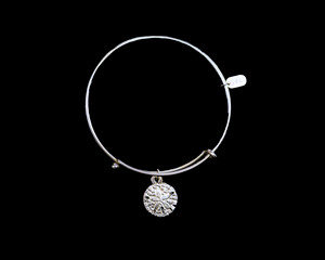 The beautiful adjustable bracelet is decorated with a Sand Dollar charm.  The dimensions of the charm are .59" x .59".  The product ID is NC 07-105-S.

This bracelet is a one size for most, with an adjustable wire band.  Each bracelet can be customized with different unique charms to attach.  All parts are made in the USA!.

The silver bracelets are steel with rhodium plating.  They are e-coated to help prevent tarnishing.

The Sand Dollar charm is a lead free casted pewter.