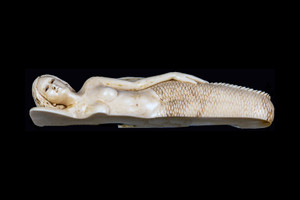 This is a unique hand carved eco-ivory Large Laying Down Mermaid.  The dimensions of the Large Laying Down Mermaid are 5.21" x 1.15" x 0.86".  The SKU is C-52.  

This stunning Large Laying Down Mermaid will make a great addition to any room in the house.  You can place it on any flat surface to display, or a great gift for children to have.

All statues are hand carved in clay.  We then make a mold of the original piece before producing them into the final acrylic resin product with an antique finish.