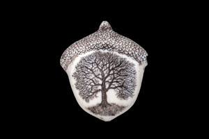 This is a beautiful originally hand etched Oak Tree designed pin/pendant.  The unique shape of the piece is an Oak Nut. The backing of this piece has the findings to be a pin, as well as a pendant.  They come with an 18" Silver Plated Chain.  This is part of the incredible line of Mossup Valley Designs that we carry, with the wonderful artist Rachel Badeau.  The dimensions of the necklace are 1.43"x 1.69" x 0.51".  The SKU is MVD PN 15.

Rachel Badeau has been etching and engraving in a variety of media for over thirty years.  Her work, characterized by fine line and intricate detail, attempts to touch the hearts and emotions of others.  All while reflecting her love of animals, nature and the human spirit.  

The resin scrimshaw piece is originally hand etched by Rachel Badeau.  We make a mold of the original piece and do an open cast pour of our resin mixture.  The pieces are removed from the mold and sanded and inked.