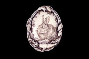 MVD PN - 1 Bunny with Carrot's.  This distinct originally hand etched Horse designed pin/pendant. The backing of this piece has the findings to be a pin, as well as a pendant.  They come with an 18" Silver Plated Chain.  This is part of the incredible line of Mossup Valley Designs that we carry, with the wonderful artist Rachel Badeau.  The dimensions of the necklace are 1.43" x 1.87" x 0.36".  The SKU is MVD PN 1.

Rachel Badeau has been etching and engraving in a variety of media for over thirty years.  Her work, characterized by fine line and intricate detail, attempts to touch the hearts and emotions of others.  All while reflecting her love of animals, nature and the human spirit.  

The resin scrimshaw piece is originally hand etched by Rachel Badeau.  We make a mold of the original piece and do an open cast pour of our resin mixture.  The pieces are removed from the mold and sanded and inked.