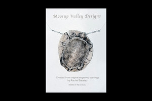 MVD PN 45 Turtle Carded.  This distinct originally hand etched Turtle designed pin/pendant.  The backing of this piece has the findings to be a pin, as well as a pendant.  They come with an 18" Silver Plated Chain.  This is part of the incredible line of Mossup Valley Designs that we carry, with the wonderful artist Rachel Badeau.  The dimensions of the necklace are 1.43" x 1.65" x 0.72".  The SKU is MVD PN 45.

Rachel Badeau has been etching and engraving in a variety of media for over thirty years.  Her work, characterized by fine line and intricate detail, attempts to touch the hearts and emotions of others.  All while reflecting her love of animals, nature and the human spirit.  

The resin scrimshaw piece is originally hand etched by Rachel Badeau.  We make a mold of the original piece and do an open cast pour of our resin mixture.  The pieces are removed from the mold and sanded and inked.