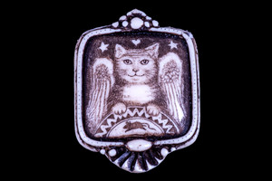 This distinct originally hand etched Angel Cat designed pin/pendant.  The Angel Cat design features a cat and a mouse.  The backing of this piece has the findings to be a pin, as well as a pendant.  They come with an 18" Silver Plated Chain.  This is part of the incredible line of Mossup Valley Designs that we carry, with the wonderful artist Rachel Badeau.  The dimensions of the necklace are 1.26" x 1.71" x 0.43".  The SKU is MVD PN 4.

Rachel Badeau has been etching and engraving in a variety of media for over thirty years.  Her work, characterized by fine line and intricate detail, attempts to touch the hearts and emotions of others.  All while reflecting her love of animals, nature and the human spirit.  

The resin scrimshaw piece is originally hand etched by Rachel Badeau.  We make a mold of the original piece and do an open cast pour of our resin mixture.  The pieces are removed from the mold and sanded and inked.