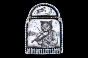 This distinct originally hand etched Hey Diddle Diddle designed pin/pendant. The design comes with a cat playing a fiddle with a cow jumping over the moon on top.  They come with an 18" Silver Plated Chain.  This is part of the incredible line of Mossup Valley Designs that we carry, with the wonderful artist Rachel Badeau.  The dimensions of the necklace are 1.24" x 1.71" x 0.44".  The SKU is MVD PN 48.

Rachel Badeau has been etching and engraving in a variety of media for over thirty years.  Her work, characterized by fine line and intricate detail, attempts to touch the hearts and emotions of others.  All while reflecting her love of animals, nature and the human spirit.  

The resin scrimshaw piece is originally hand etched by Rachel Badeau.  We make a mold of the original piece and do an open cast pour of our resin mixture.  The pieces are removed from the mold and sanded and inked.