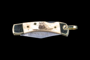 This unique hand etched Tall Ship design on a 440 Stainless Steel Blade LB 1 Knife.  This beautiful knife is part of the Scrimshaw Collection, with those words laser engraved into the blade.  The LB 1 knifes come with the pictured leather sheath and each scale is made with Bovine Bone.  The LB 1 Knife has bolsters and shackle that are nickel silver with brass pins and liner.  It is a lock blade knife and a very useful pocket knife. The knife also has a key chain ring at the end of the knife.  The dimensions of the LB 1 Pocket Knife with the blade closed are 2.24" x 0.68" x 0.31".  The blade itself is approximately 1.67" making the width of the knife with an open blade 3.91".  The SKU is LB-1 401.

The scrimshaw is inked with black india ink and sealed with renaissance wax, which is used by museums for antique restoration.  It also helps bring out the beauty of the artwork as well as in the cow bone. The knife is water resistant, but not waterproof.