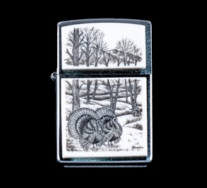 This is a beautiful originally hand etched Eco-Ivory Scrimshaw Turkey Designed Zippo!  In the detailed image is a hunter along the tree line. The top of the flip lighter has a Mountain View with Tree's design.  The Zippo is a Brushed Chrome finish. Each lighter has a bottom stamp signifying the year it was made, is refillable. All windproof lighters are American made in Bradford, PA factory and come packaged in a gift box.  This is part of the Save the Elephant Collection and was originally hand etched by Linda Layden.  The SKU is NC 54 - 168.

The Zippo Lighter is 2.24" x 1.51" x 0.59".  It weighs 2.04 oz.