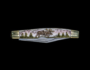 Moose Dual Blade Pocket Knife.  This beautiful hand etched Moose design on a 440 Stainless Steel Dual Blade Knife.  The moose is walking in the forrest in front of mountains.  The knife design is similar to the Shrade 33 knife.  This beautiful knife is part of the Scrimshaw Collection, with those words laser engraved into the blade.  The DB 33 knifes come with the pictured leather sheath and each scale is made with Bovine Bone.  The DB 33 Knife has bolsters that are nickel silver with brass pins and liner.  It is a dual blade knife and a very useful pocket knife.  The dimensions of the DB 33 Pocket Knife with the blade closed are 3.28" x 0.69" x 0.50".  The large blade itself is approximately 2.45" making the width of the knife with an open blades 5.73".  The small blades length is approximately 1.77".  The SKU is DB 33 - 102C.