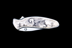 NC 1600 Chive Wolf Pocket Knife.  This stunning originally hand etched Wolf design on a Kershaw 1600 Chive Speedsafe Assisted Opening Pocket Knife.  The back of the knife has a belt clip/ money clip and the knifes come with the pictured sheath.  It is a lock blade knife and a useful pocket knife.  The artwork was originally hand etched by Linda Layden.  The dimensions of the Kershaw 1600 Chive Pocket knife with the blade closed are 2.95" x 0.92" x 0.53".  The blade itself is approximately 1.9" making the width of the knife with an open blade 4.85".  The SKU is NC 1600 - 105.

This unique etching has a wolf howling at the moon in the background, with a face of another wolf in the foreground.  This design is set in a mountainess region.  

Linda Layden has been making beautiful works of art in the scrimshaw field for over 40 years.  Originally a hobby that became a full time job.  Her work can be found in gift shops, galleries and museums across the world.