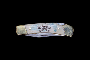 LB 5 600C.  This beautiful etched Colored Scrimshaw Skull and Crossbone design on a 440 Stainless Steel Blade LB 5 Knife.  This beautiful knife is part of the Scrimshaw Collection, with those words laser engraved into the blade.  The LB 5 knifes come with the pictured leather sheath and each scale is made with Bovine Bone.  The LB 5 Knife has bolsters and shackle that are nickel silver with brass pins and liner.  It is a lock blade knife and a very useful pocket knife. The dimensions of the LB 5 Pocket Knife with the blade closed are 3.71" x 0.90" x 0.39".  The blade itself is approximately 2.80" making the width of the knife with an open blade 6.51".  The SKU is LB-5 600C.

The scrimshaw is inked with black india ink and sealed with renaissance wax, which is used by museums for antique restoration.  It also helps bring out the beauty of the artwork as well as in the cow bone. The knife is water resistant, but not waterproof.