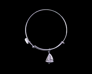 The beautiful adjustable bracelet is decorated with a Sailboat Charm.  The product ID is NC 07-902-S.

This bracelet is a one size for most, with an adjustable wire band.  Each bracelet can be customized with different unique charms to attach.  All parts are made in the USA!.

The silver bracelets are steel with rhodium plating.  They are e-coated to help prevent tarnishing.

The Sailboat Charm is a lead free casted pewter.