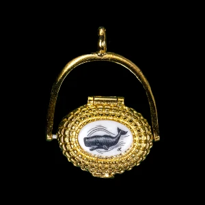 This is a incredibly detailed 22K Plated Gold Nantucket Basket Pendant with a replica scrimshaw with a Sperm Whale design top.  Inside the basket is a mini penny.  The basket on it's own has the following dimensions, .78"x .48"x .77".  The pendant holder add .22" x .85".  Each pendant weighs .31 ounces.  All the pendants come with an 18" gold chain. The item number is GNB 121.

This Nantucket Lightship basket pendant is made in pewter and was plated in 22k Gold.  These beautiful baskets are similar to what is seen on the Netflix hit, Sirens

Nantucket lightship baskets, characterized by their rattan staves, cane weavers, and wooden bases, originated on the island's lightships in the mid-1800s. Initially, these baskets were a way for lightship crewmen to pass the time during long deployments and were primarily utilitarian. Over time, the baskets evolved, becoming more refined and sought after as souvenirs of Nantucket.

Keeping with the tradition of a penny in the basket.  A penny is placed inside the basket to symbolize good luck.  Each of our basket pendants have a mini penny inside to carry on the tradition.  

Linda Layden has been making beautiful works of art in the scrimshaw field for over 40 years.  Originally a hobby that became a full time job.  Her work can be found in gift shops, galleries and museums across the world.  

The resin scrimshaw piece is originally hand etched by Linda Layden.  We make a mold of the original piece and do an open cast pour of our resin mixture.  The pieces are removed from the mold and sanded and inked with Indian Ink.

We believe that serving nature is one of the commissions that we as humans have been given here on earth.  We wish to lend our resources to those charged with protecting elephants from poaching.

On a monthly basis we donate to organizations whose purpose to protect the elephants and other species throughout the planet.  We focus our donations on organizations that put the money to good use and have a low overhead. With the majority of incoming funds going back to saving the elephants!

American Made
Nantucket Basket Pendant
22k Gold Plated
Pewter Base 
Mini Penny
18" Gold Chain
Nautical Design
Sperm Whale 
Resin Scrimshaw Design Top
Lifetime Guarantee