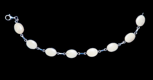 This trendy round mammoth ivory is inlayed into an elegant oval shaped shaped sterling silver bracelet.  This bracelet has one sterling silver links in between the oval mammoth pieces.  The dimension of the bracelet is approximately 7.4" x .45".