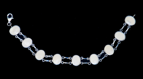 This trendy round mammoth ivory is inlayed into an elegant oval shaped sterling silver bracelet.  This bracelet has two sterling silver links in between the oval mammoth pieces.  The dimension of the bracelet is approximately 7.2" x .49".
