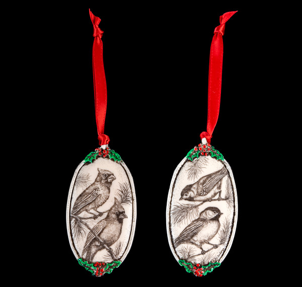 This is a beautiful double sided ornament with a Bird theme.  This is part of the incredible line of Mossup Valley Designs that we carry, with the wonderful artist Rachel Badeau.  The dimensions of the ornament are 3.28" x 1.61".  The SKU is MVD ORN 6.

On this double sided ornament, a Bird if prominently featured on both sides.  On one side there is Cardinal design.  On the other side of the ornament, there is a Robin

Rachel Badeau has been etching and engraving in a variety of media for over thirty years.  Her work, characterized by fine line and intricate detail, attempts to touch the hearts and emotions of others.  All while reflecting her love of animals, nature and the human spirit.