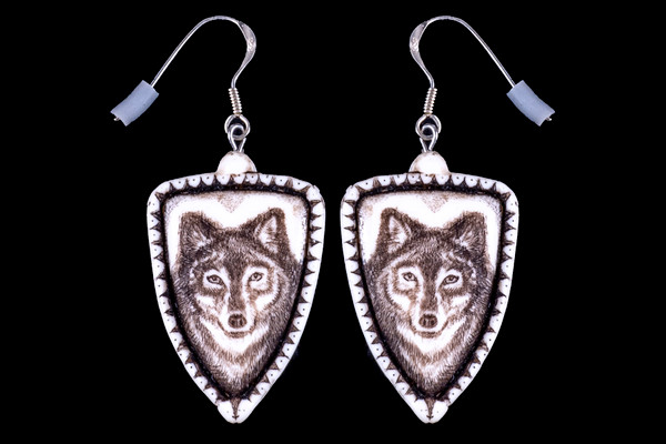 This is a beautiful originally hand etched Wolf French Wire Earring set. This is part of the incredible line of Mossup Valley Designs that we carry, with the wonderful artist Rachel Badeau.  All the earrings come carded.  The dimensions of the earrings are .90" x 1.36" x 0.18".  The SKU is MVD ER 01.

Rachel Badeau has been etching and engraving in a variety of media for over thirty years.  Her work, characterized by fine line and intricate detail, attempts to touch the hearts and emotions of others.  All while reflecting her love of animals, nature and the human spirit.  

The resin scrimshaw piece is originally hand etched by Rachel Badeau.  We make a mold of the original piece and do an open cast pour of our resin mixture.  The pieces are removed from the mold and sanded and inked.