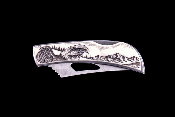 This beautiful originally hand etched Eagle Face design on a Stainless Steel Silver Hawk Knife.  The back of the knife has a belt clip and all the knifes come with the pictured sheath.  It is a lock blade knife.  The artwork was originally hand etched by Linda Layden.  The dimensions of the Silver Hawk knife with the blade closed are 3.00" x 0.96" x 0.55".  The blade itself is approximately 2.35" making the width of the knife with an open blade 5.35".  The SKU is NC 14 - 114.