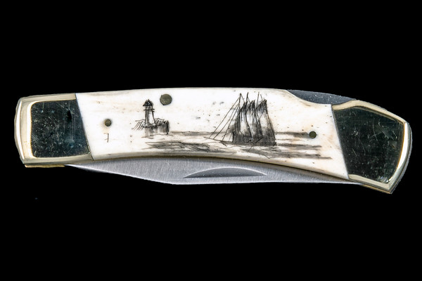 This distinct hand etched Classic Black inked Scrimshaw Ship and Lighthouse design on a 440 Stainless Steel Blade LB 5 Knife.  This beautiful knife is part of the Scrimshaw Collection, with those words laser engraved into the blade.  The LB 5 knifes come with the pictured leather sheath and each scale is made with Bovine Bone.  The LB 5 Knife has bolsters and shackle that are nickel silver with brass pins and liner.  It is a lock blade knife and a very useful pocket knife. The dimensions of the LB 5 Pocket Knife with the blade closed are 3.71" x 0.90" x 0.39".  The blade itself is approximately 2.80" making the width of the knife with an open blade 6.51".  The SKU is LB-5 401.

The scrimshaw is inked with black india ink and sealed with renaissance wax, which is used by museums for antique restoration.  It also helps bring out the beauty of the artwork as well as in the cow bone. The knife is water resistant, but not waterproof.