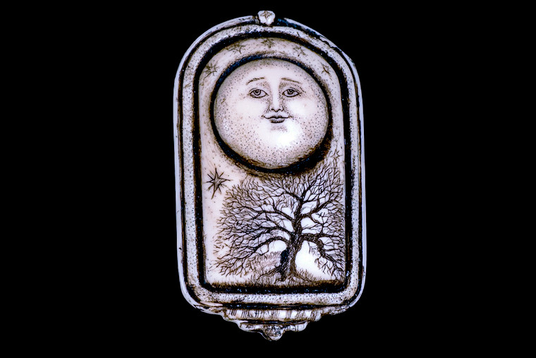 MVD PN 07 Moon and Tree of Life Zoom.  This unique originally hand etched MoonTree designed pin/pendant. The backing of this piece has the findings to be a pin, as well as a pendant.  They come with an 18" Silver Plated Chain.  This is part of the incredible line of Mossup Valley Designs that we carry, with the wonderful artist Rachel Badeau.  The dimensions of the necklace are 1.27" x 2.21" x 0.51".  The SKU is MVD PN 7

Rachel Badeau has been etching and engraving in a variety of media for over thirty years.  Her work, characterized by fine line and intricate detail, attempts to touch the hearts and emotions of others.  All while reflecting her love of animals, nature and the human spirit.  

The resin scrimshaw piece is originally hand etched by Rachel Badeau.  We make a mold of the original piece and do an open cast pour of our resin mixture.  The pieces are removed from the mold and sanded and inked.