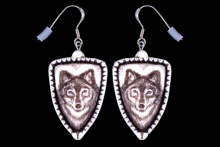 This is a beautiful originally hand etched Wolf French Wire Earring set. This is part of the incredible line of Mossup Valley Designs that we carry, with the wonderful artist Rachel Badeau.  All the earrings come carded.  The dimensions of the earrings are .90" x 1.36" x 0.18".  The SKU is MVD ER 01.

Rachel Badeau has been etching and engraving in a variety of media for over thirty years.  Her work, characterized by fine line and intricate detail, attempts to touch the hearts and emotions of others.  All while reflecting her love of animals, nature and the human spirit.  

The resin scrimshaw piece is originally hand etched by Rachel Badeau.  We make a mold of the original piece and do an open cast pour of our resin mixture.  The pieces are removed from the mold and sanded and inked.