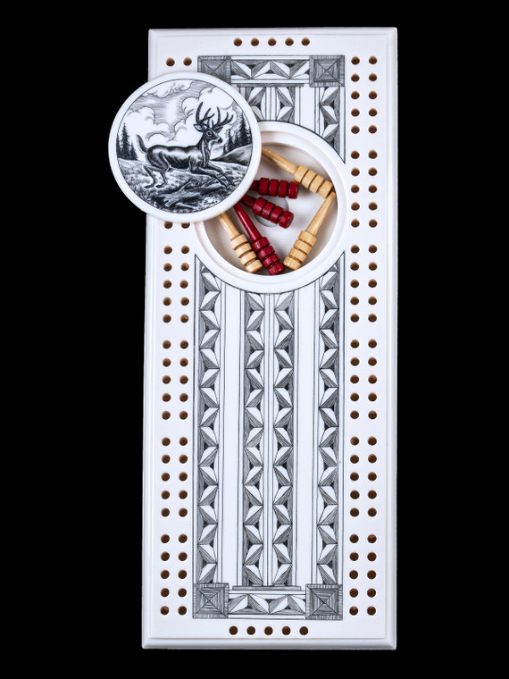 This is a unique originally hand etched Jumping Deer Eco - Ivory Scrimshaw Cribbage Board!   The center circular piece has a magnet holding it in place.  Pushing on the base of the piece pops the Large round off the board, where the pegs are stored.  All cribbage boards come with 3 red and 3 white/yellow wooden pegs. 

The cribbage board itself is made for two players or teams.  The board has a native geometic design that was originally hand etched.  The large round piece has a magned on the back to keep it secured to the board and store the pegs.  The pegs are made of wood.  This is part of the Save the Elephant Collection and was originally hand etched by Linda Layden.  The SKU is NC 53 - 103.

The Cribbage Board is 8.50" x 3.46" x 0.46".  It weighs 11.28 oz.