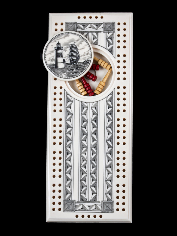 This wonderful two person and our two team cribbage boards is a beautiful accent piece for your home or take it on the road for use as a travel cribbage board.  With the magnet holding the center piece and pegs in place it is a stunning travel cribbage board. 

This is a beautiful originally hand etched Ship and Lighthouse Eco - Ivory Scrimshaw Cribbage Board!  The center circular piece has a magnet holding it in place.  Pushing on the base of the piece pops the Large round off the board, where the pegs are stored.  All cribbage boards come with 3 red and 3 white/yellow wooden pegs. 

The cribbage board itself is made for two players or teams.  The board has a native geometric design that was originally hand etched.  The large round piece has a magnet on the back to keep it secured to the board and store the pegs.  The pegs are made of wood.  This is part of the Save the Elephant Collection and was originally hand etched by Linda Layden.  The SKU is NC 53 - 406.

The Cribbage Board is 8.50" x 3.46" x 0.46".  It weighs 11.28 oz.