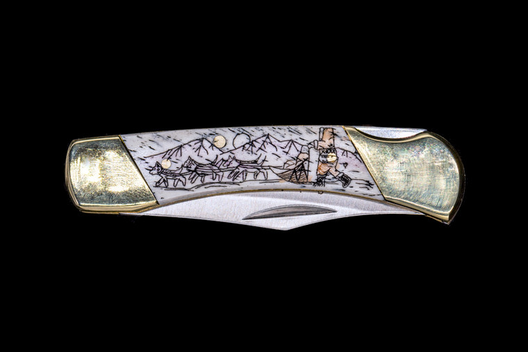Dog Sled LB3 Pocket Knife.  This stunning hand etched Colored Dog Sled design on a 440 Stainless Steel Blade LB 3 Knife. This beautiful knife is part of the Scrimshaw Collection, with those words laser engraved into the blade.  The LB 3 knifes come with the pictured leather sheath and each scale is made with Bovine Bone.  The LB 3 Knife has bolsters and shackle that are nickel silver with brass pins and liner.  It is a lock blade knife and a very useful pocket knife. The dimensions of the LB 3 Pocket Knife with the blade closed are 2.97" x 0.76" x 0.31".  The blade itself is approximately 2.21" making the width of the knife with an open blade 5.18".  The SKU is LB-3 242C.
