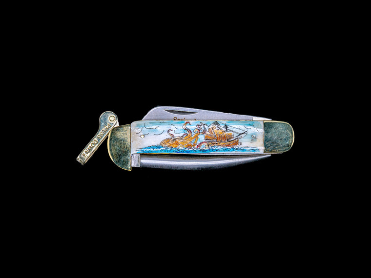 This stunning hand etched Octopus and Ship Colored design on a 440 Stainless Steel Blade Marlin Spike with a foldable bladed knife.  The stunning design has a giant Octopus attacking a tall ship at sea.  The Marlin Spike has a lock feature, while the knife blade is foldable.

This beautiful knife is part of the Scrimshaw Collection, with those words laser engraved into the blade.  The MS knifes come with the pictured leather sheath and each scale is made with Bovine Bone.  The MS Knife has bolsters and shackle that are nickel silver with brass pins and liner.  It is a lock blade Marlin Spike with a very useful pocket knife. The Marlin Spike is made of Stainless Steel.  The dimensions of the MS Knife with the blade closed are 4.11" x 2.17" x 0.69".  The blade itself is approximately 2.91" making the width of the knife with an open blade 7.02".  The Marlin Spike is 3.05" long.  The SKU is MS 409C.