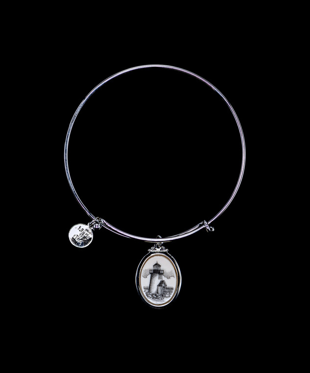 NC 07 816-SEV Adjustable Bracelet Brant Point Light Charm Display.  The beautiful adjustable bracelet is decorated with Scrimshaw Lighthouse Charm.  The product ID is NC 07-816-SE.  The design of the Lighthouse, is that of Brant Point Light which is located in Nantucket, MA.  

This bracelet is a one size for most, with an adjustable wire band.  Each bracelet can be customized with different unique charms to attach.  All parts are made in the USA!.

The Eco-Ivory Scrimshaw Charm is 13x18.  The artwork was originally hand etched by Linda Layden.

Linda Layden has been making beautiful works of art in the scrimshaw field for over 40 years.  Originally a hobby that became a full time job.  Her work can be found in gift shops, galleries and museums across the world.  

We make a mold of the original piece and do an open cast pour of our resin mixture.  The pieces are removed from the mold and sanded and inked.