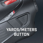 Bushnell Golf Tour V5 Shift laser rangefinder demonstration photo of yards/meters button. Bushnell Golf Tour V5 Shift laser rangefinder demonstration photo of yards/meters button.