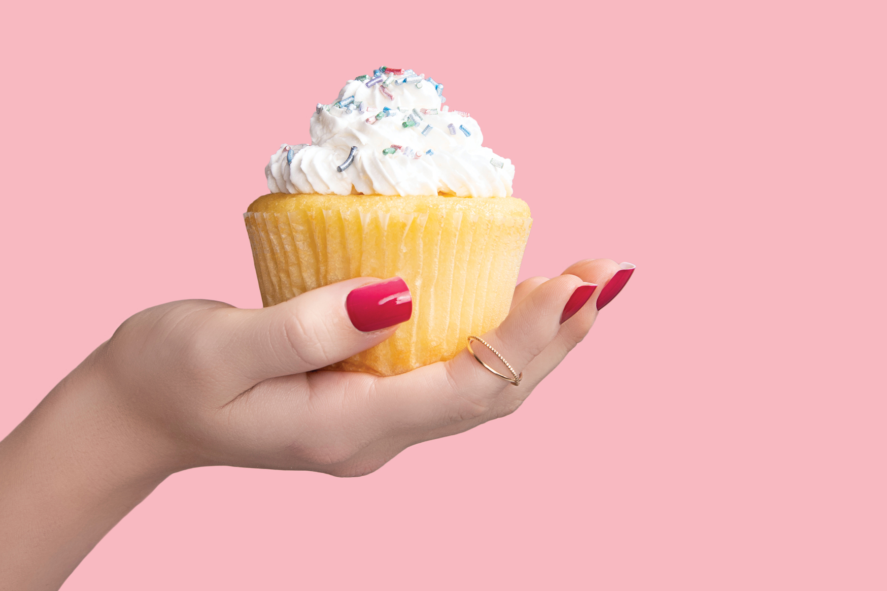 hand with color changing press on nails holding a cupcake