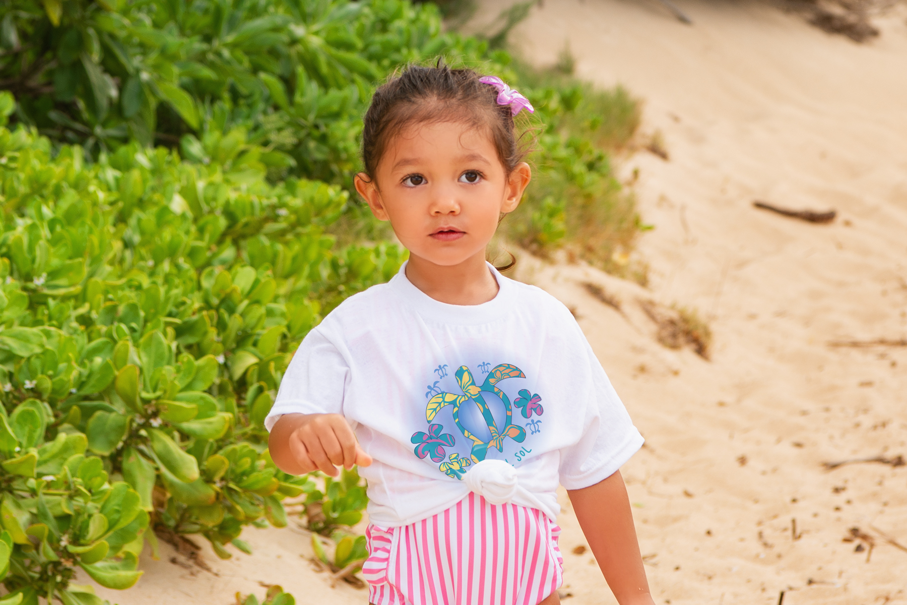 toddler wearing color changing shirt on the beach