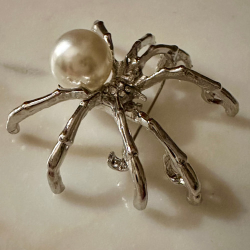 Alloy metal, synthetic pearl brooch or charm. 1.5' x 2'
Spiders represent balance, intuition, and the intricate connections between fate and free will.