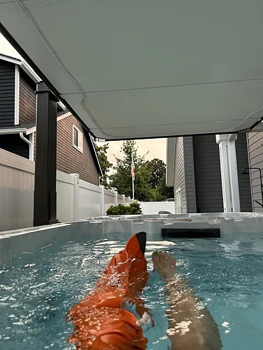 person wearing a waterproof leg cast cover while playing in a swimming pool during recovery.