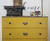 yellow dresser with black knobs
