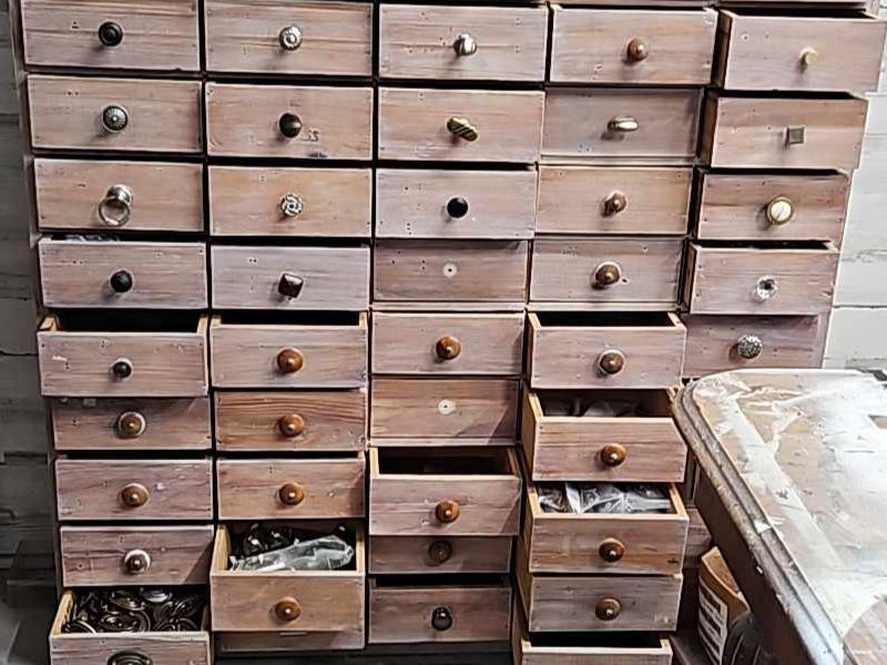 Many-drawered cabinet for storing knobs and pulls.