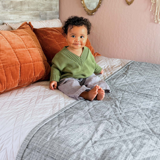 baby sitting on a bed quilt