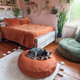round brick red dog bed in a bedroom