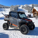 General XP 1000 with upper doors parked at a ski resort base area in deep snow