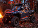 Polaris General XP upper doors installed at a fall campsite, campfire glowing in the background