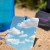 Sun Company Featherweight Mirror 3.125 in. x 4.25 in., Shown Set in Sand Reflecting Clouds