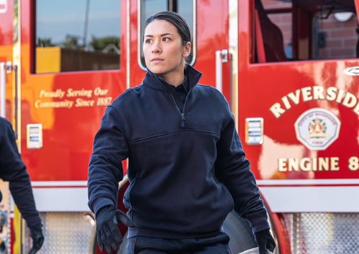 Woman firefighter in 5.11 Tactical Job Shirt - Navy blue - in front of a red fire truck.