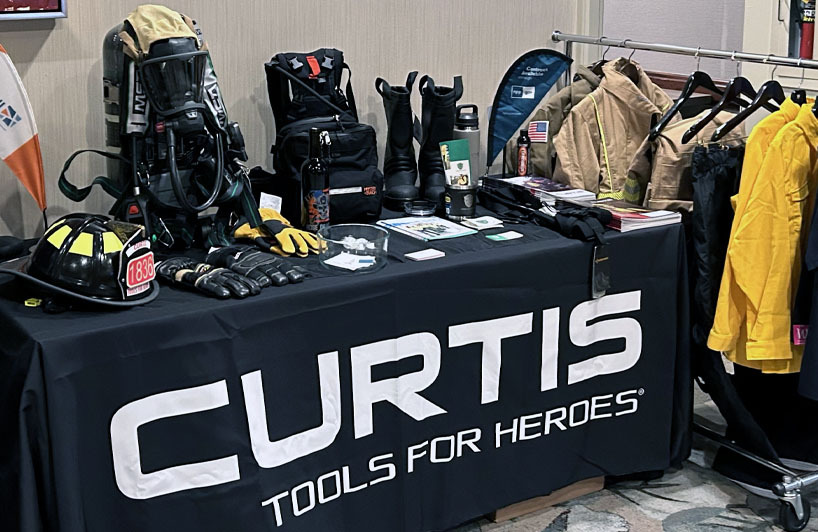 Curtis - Tools for Heroes trade show booth featuring turnouts, SCBA, boots, gloves, helmets and more.