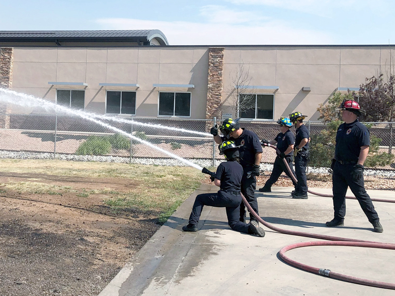 Image of multiple firefighters working with different hoses and nozzles.