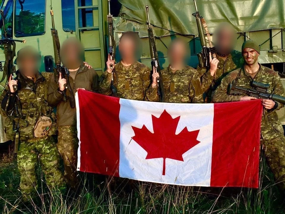 Brandon's army section holding a Canadian flag