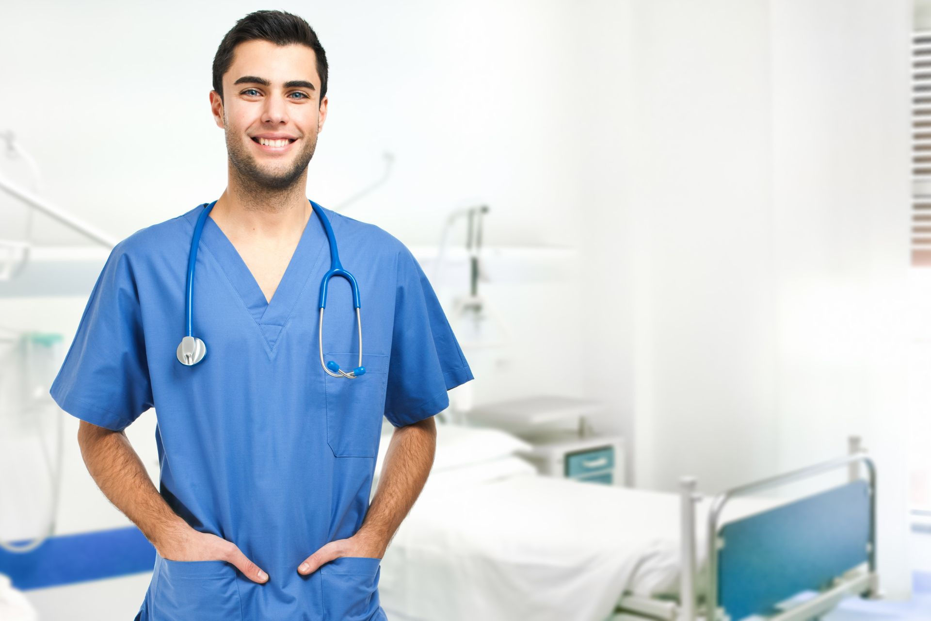 A male doctor in a Men Uniform Top from Head to Toe Uniforms, with stethoscope, ready for medical care in a hospital room