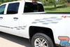 A white Chevy Silverado with high-performance vinyl graphics, including a subtle door stripe and a bold checkered flag pattern on the truck bed. Designed for durability.
