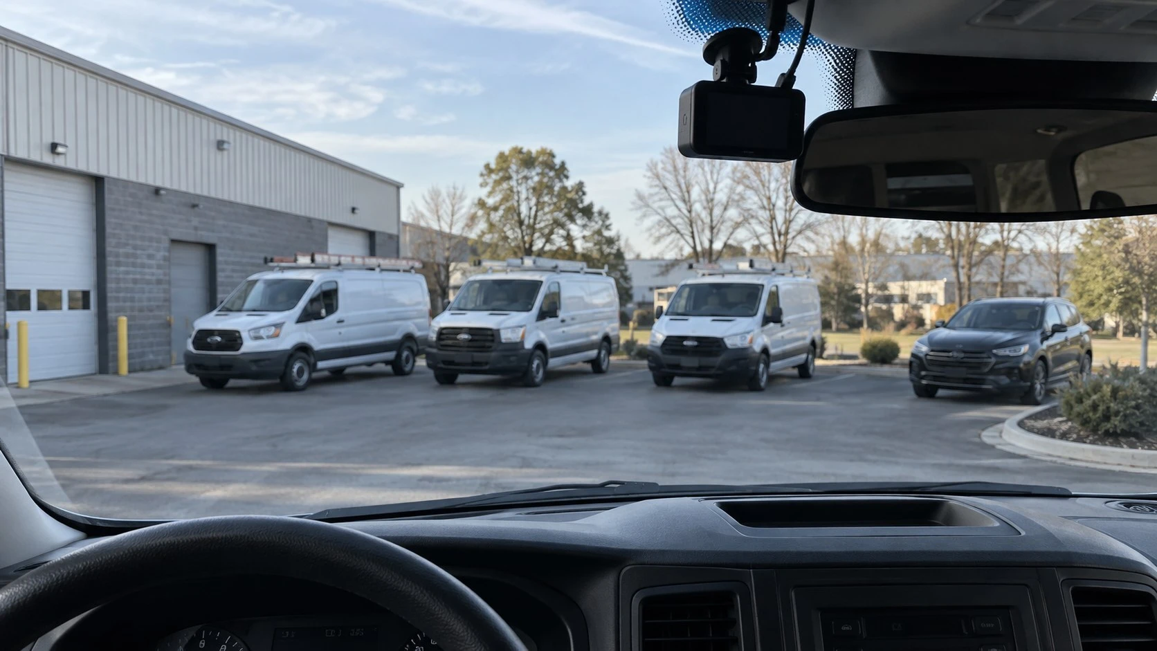 Interior view of a service van with a dash camera and fleet vehicles