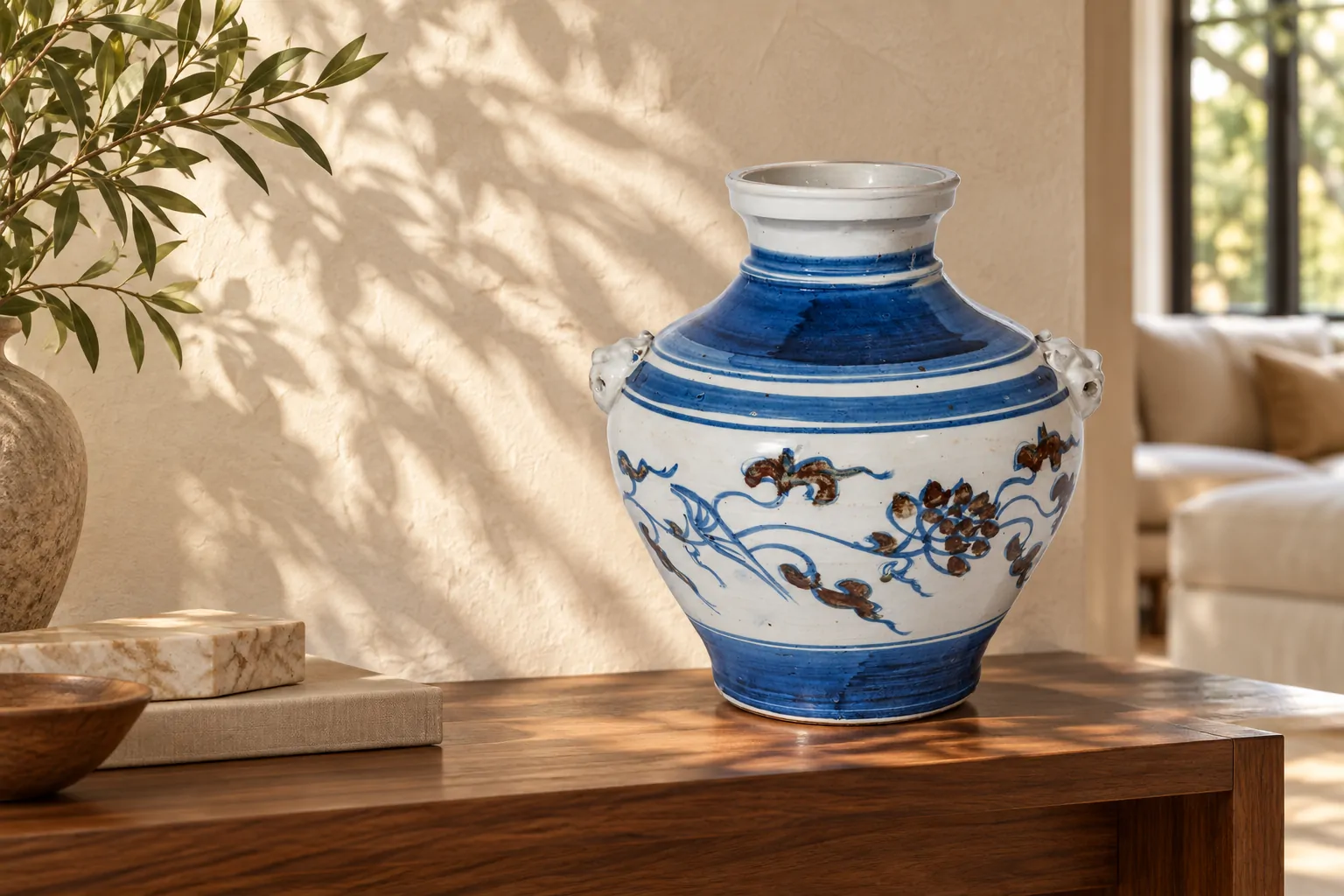 Blue-and-white lion-handle jar on a walnut console in a sunlit interior