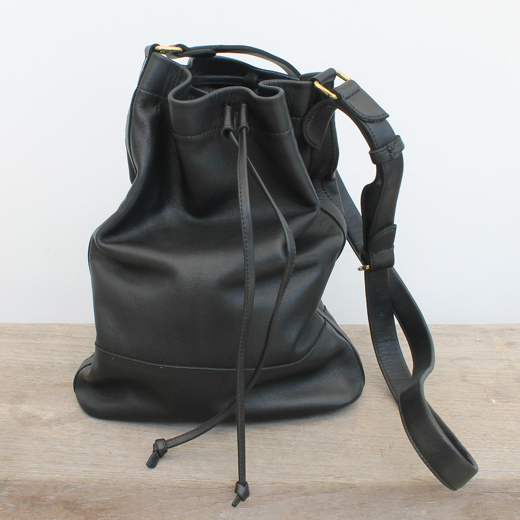 black leather handbag with drawstring strap and adjustable straps