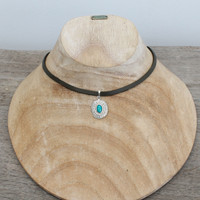 Grey leather with silver plated pendant featuring turquoise stone
