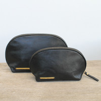 Small and large pouches with 'escape the ordinary' and 'take more detours' brass plates